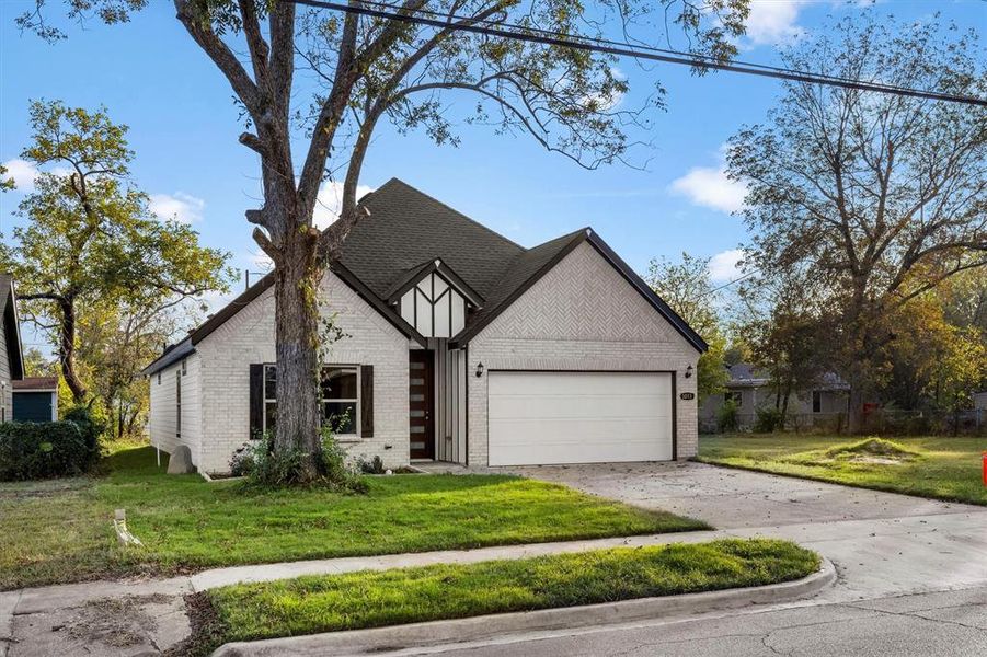 View of front of house featuring a front lawn and a garage