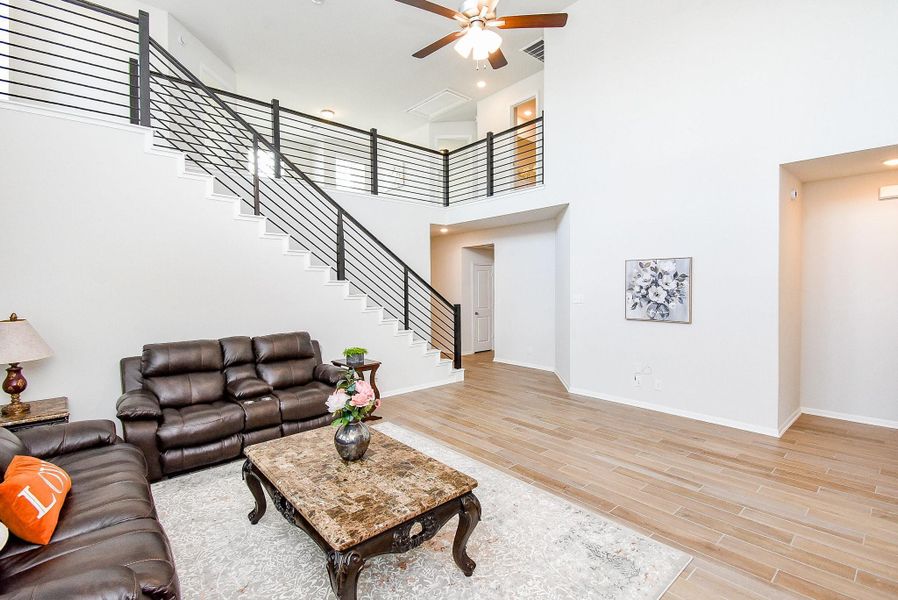 Stunning high ceilings and wood-look tile floors adorn the spacious living room. Stunning high ceilings and wood-look tile floors adorn the spacious living room.