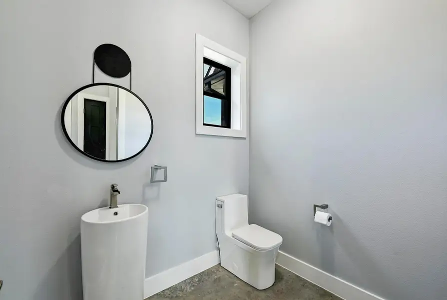 The main floor also provides a convenient guest powder room with a modern pedestal sink. The main floor also provides a convenient guest powder room with a modern pedestal sink.
