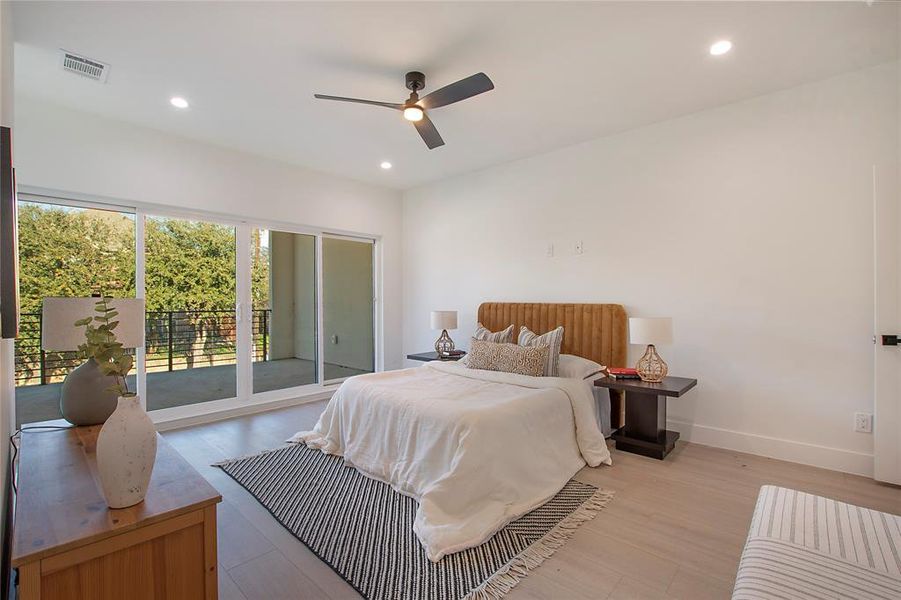 Bedroom with ceiling fan, light wood-type flooring, and access to outside