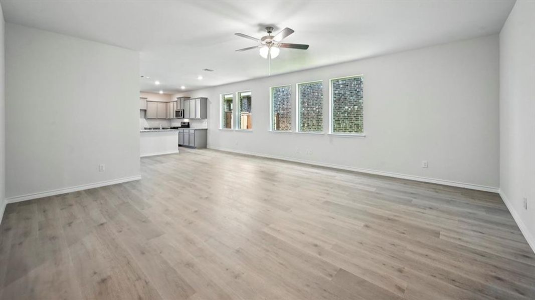 Unfurnished living room featuring light wood-type flooring, a ceiling fan, and recessed lighting Unfurnished living room featuring light wood-type flooring, a ceiling fan, and recessed lighting
