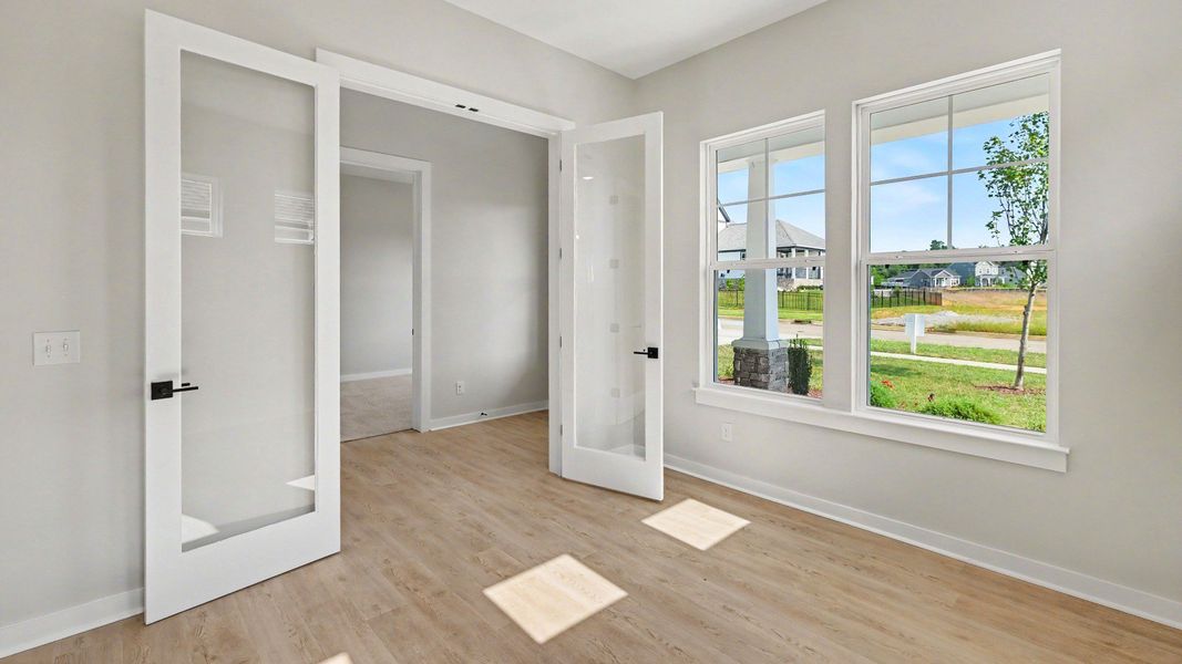 Study at the front of the home with glass privacy doors