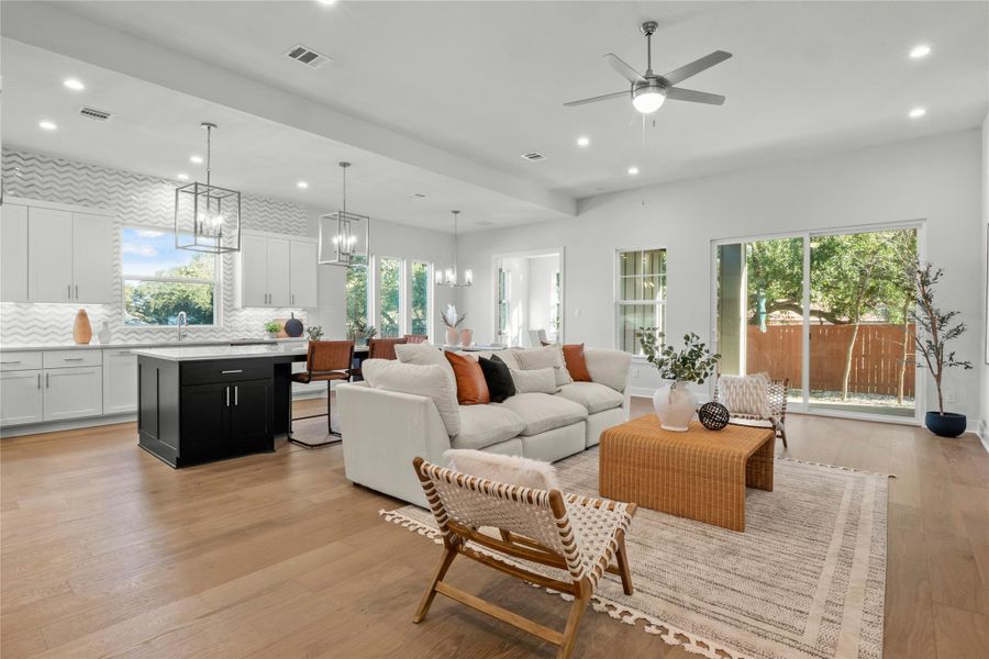 Living area featuring a chandelier, light wood-style floors, recessed lighting, and a ceiling fan Living area featuring a chandelier, light wood-style floors, recessed lighting, and a ceiling fan