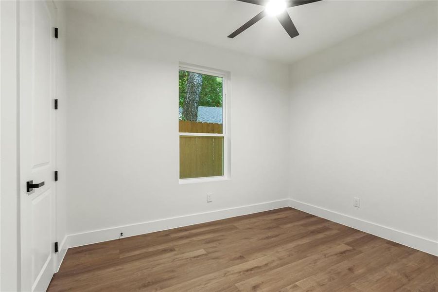 Spare room with wood finished floors and a ceiling fan Spare room with wood finished floors and a ceiling fan