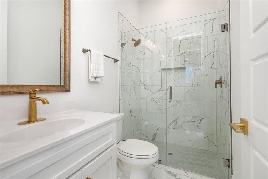 Bathroom featuring vanity and a marble finish shower
