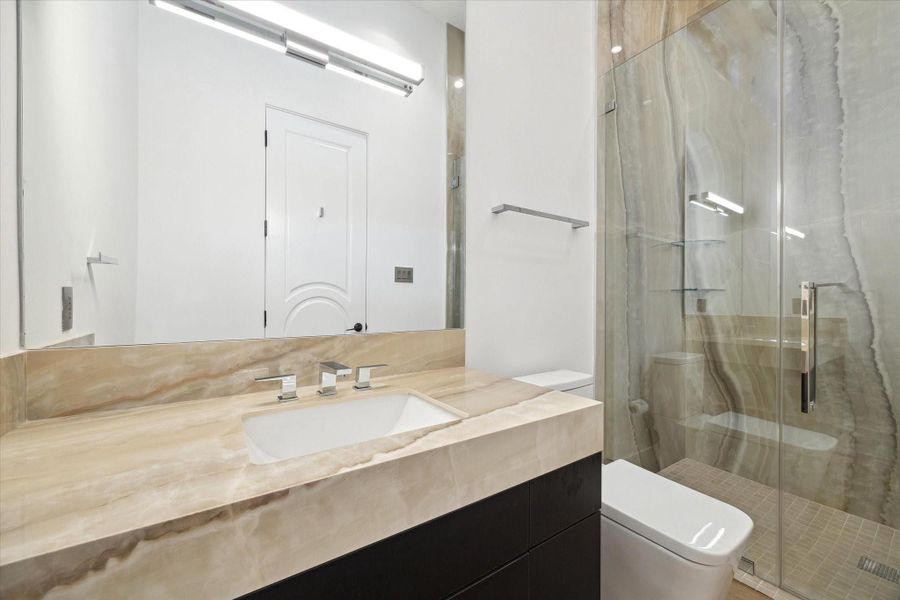 First floor en-suite guest bath with glass enclosed walk in shower
