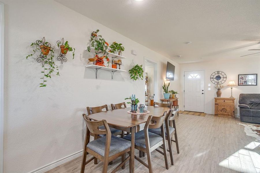 Dining space with light wood-style tile flooring and a ceiling fan Dining space with light wood-style tile flooring and a ceiling fan