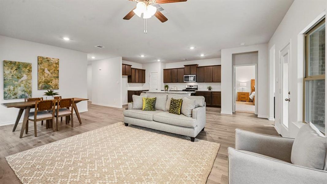 Living room with a ceiling fan, light wood-type flooring, and recessed lighting