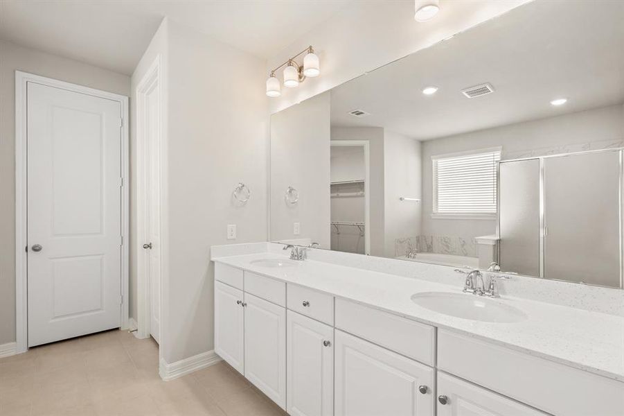 The en-suite bathroom offers a spa-like atmosphere with its elegant design, high end finishes, and tasteful lighting, creating a retreat within your own home.