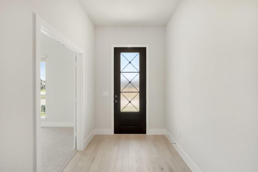 Entryway with black front door featuring decorative glass panels and light hardwood floors