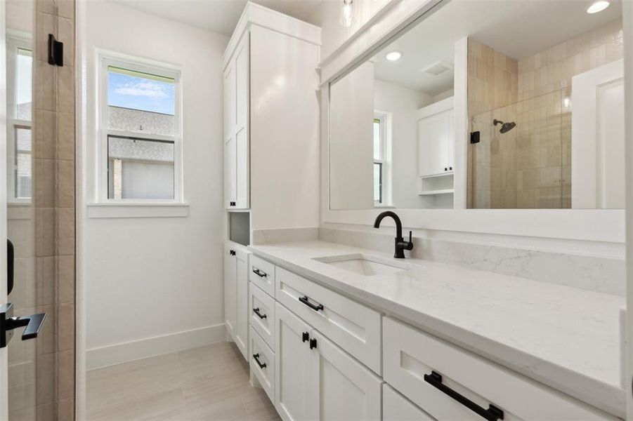 Bathroom with vanity and tiled shower