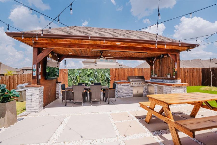 Fenced backyard with area for grilling, outdoor dining space, and a patio Fenced backyard with area for grilling, outdoor dining space, and a patio
