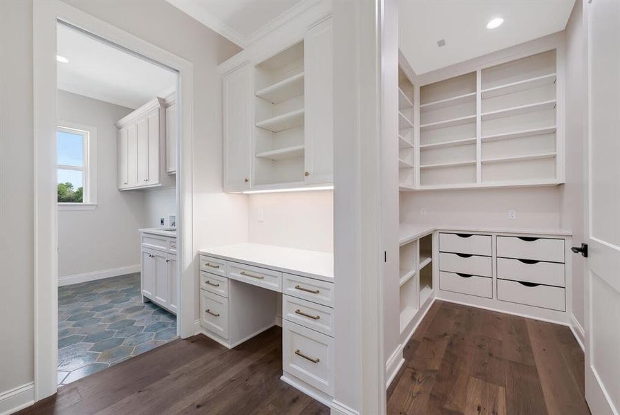 Unfurnished office featuring built in study area, dark wood finished floors, and ornamental molding Unfurnished office featuring built in study area, dark wood finished floors, and ornamental molding