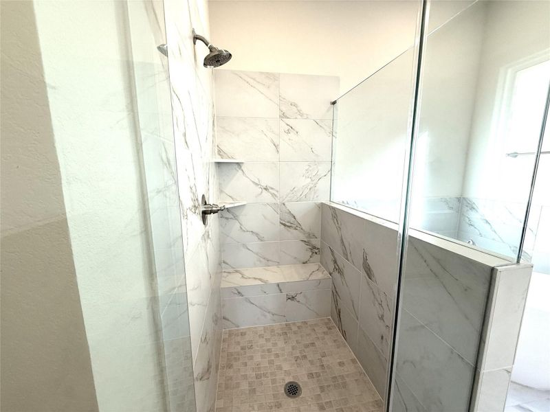 Full bathroom with a marble finish shower