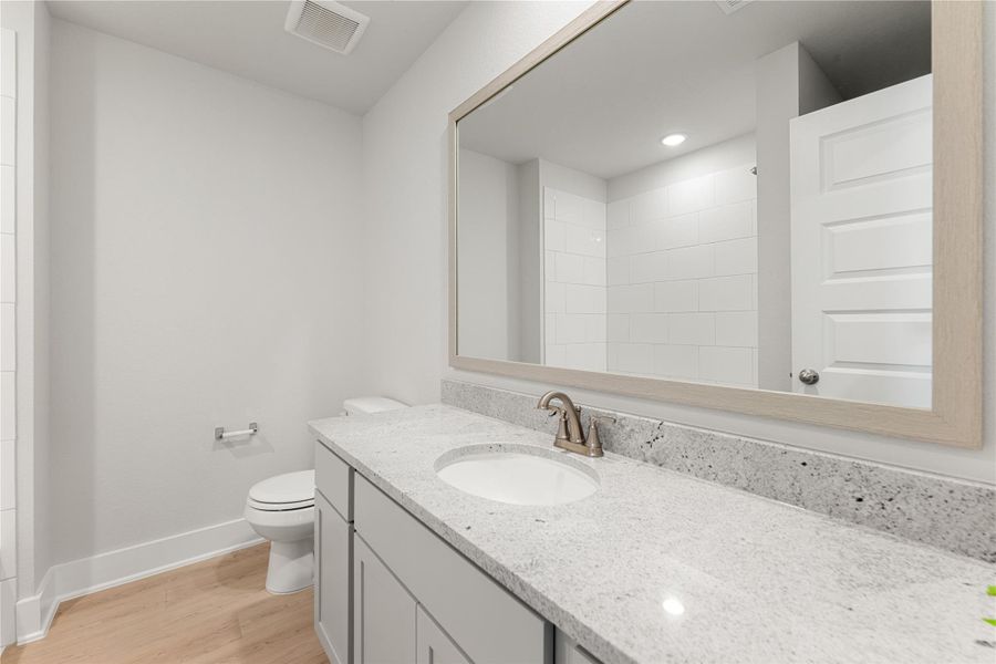 This full bath features a sleek double vanity with quartz countertops, modern fixtures, and a neutral palette. The spacious layout offers both style and functionality for shared use. This full bath features a sleek double vanity with quartz countertops, modern fixtures, and a neutral palette. The spacious layout offers both style and functionality for shared use.