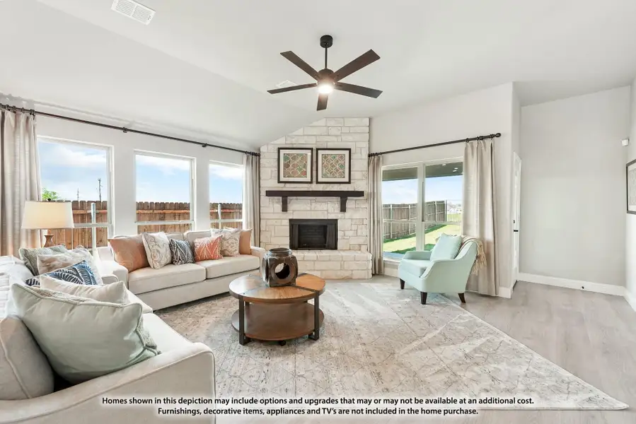 Living room with stone fireplace, vaulted ceiling, ceiling fan, and hardwood floors Living room with stone fireplace, vaulted ceiling, ceiling fan, and hardwood floors