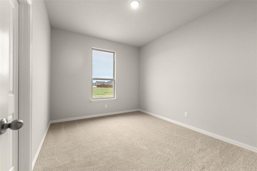 Empty room featuring light colored carpet and baseboards Empty room featuring light colored carpet and baseboards