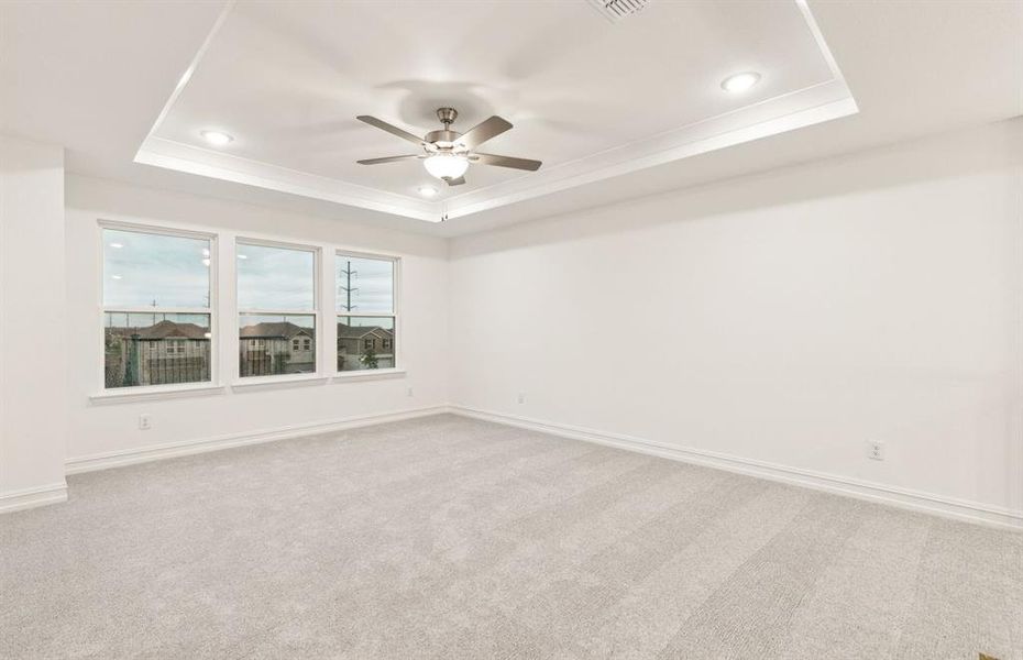 Expansive owner's suite with impressive windows and elegant tray ceiling *Real home pictured