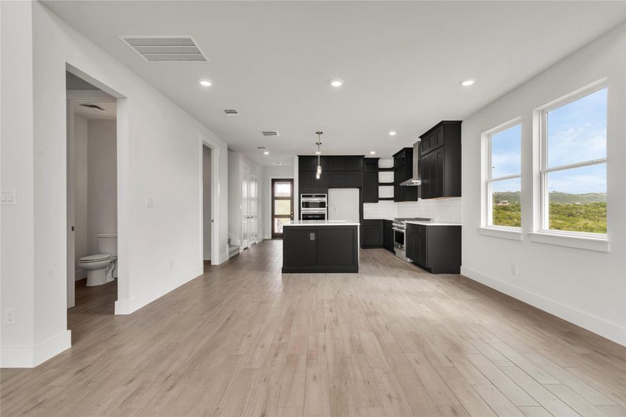 A well-lit open-concept space integrates a contemporary kitchen with an expansive living area.