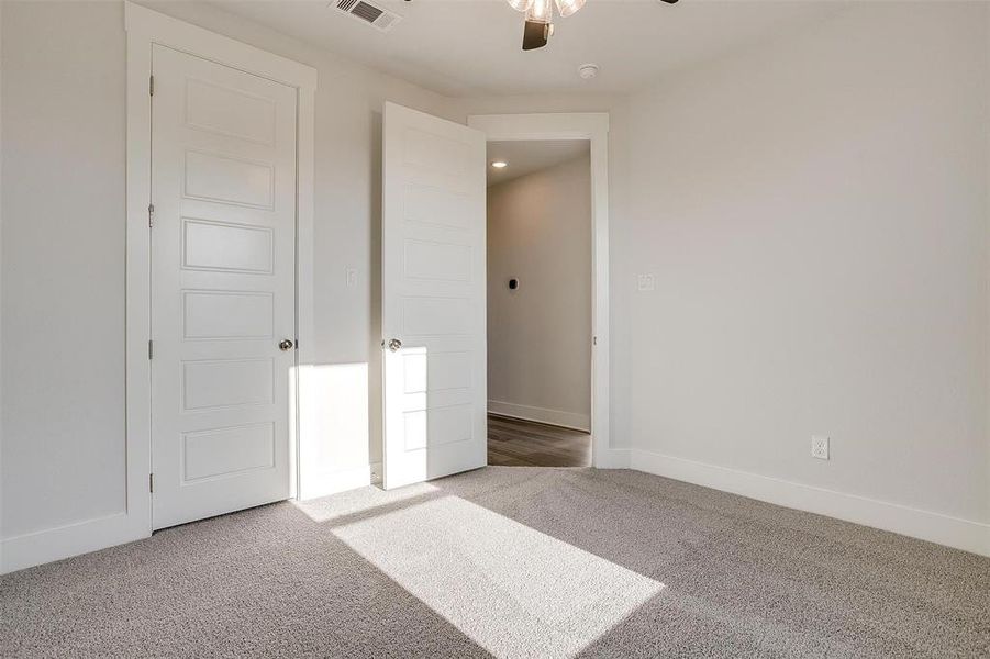 Unfurnished bedroom with carpet flooring and ceiling fan