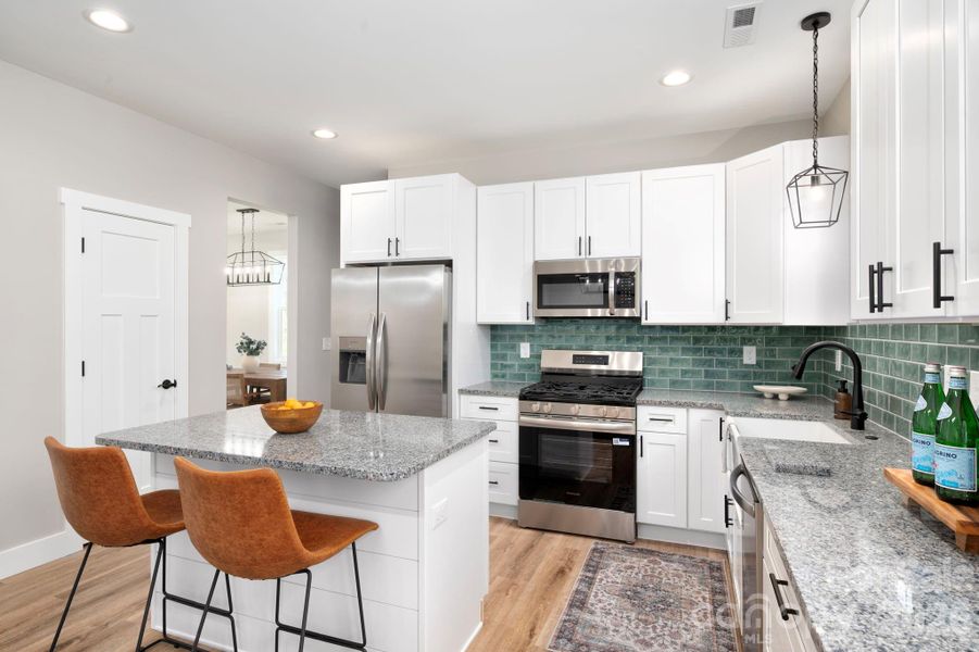 Kitchen Features Stainless Steel Appliances and Beautiful Backsplash