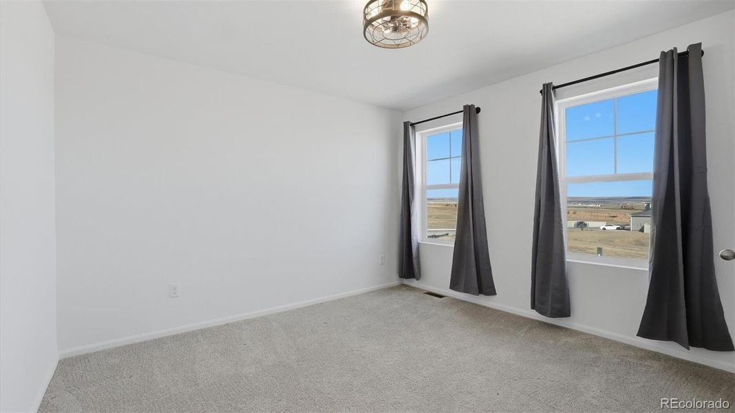 Upper Level Bedroom #2 with neutral carpet, a lighted ceiling fan, and double windows with mountain views.