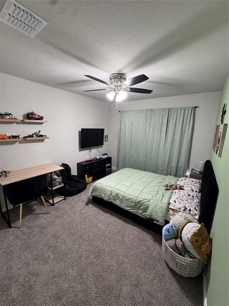 Bedroom 4 featuring a ceiling fan with integrated lighting, a window with drapery, and a wall-mounted television