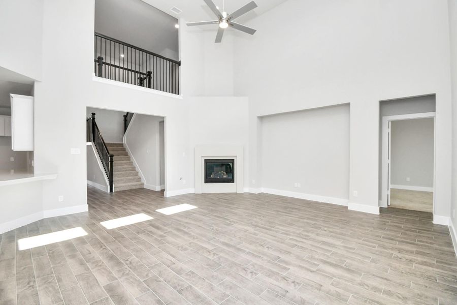 Gather the family and guests together in your lovely living room! Featuring soaring high ceilings, recessed lighting, ceiling fan, custom paint, gorgeous floors, and large windows that provide plenty of natural lighting throughout the day. Sample photo of completed home with similar floor plan. Actual colors and selections may vary.