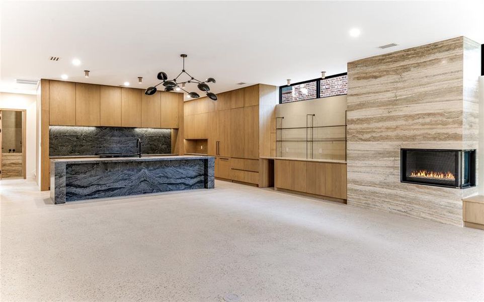 Unfurnished living room with a large fireplace, dark aggregate flooring, and recessed lighting