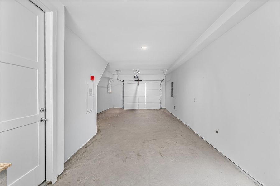 A spacious, clean garage with a concrete floor provides ample utility and storage space.