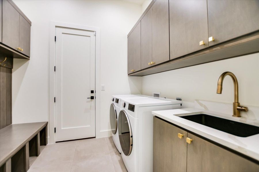 Functional laundry room featuring a utility sink, modern appliances, and ample storage.