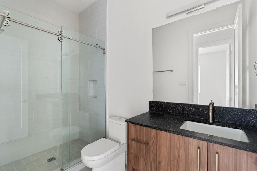 Stylish shared bath with a walk-in shower, Moen plumbing fixtures, and custom cabinetry by GoBravura. Stylish shared bath with a walk-in shower, Moen plumbing fixtures, and custom cabinetry by GoBravura.