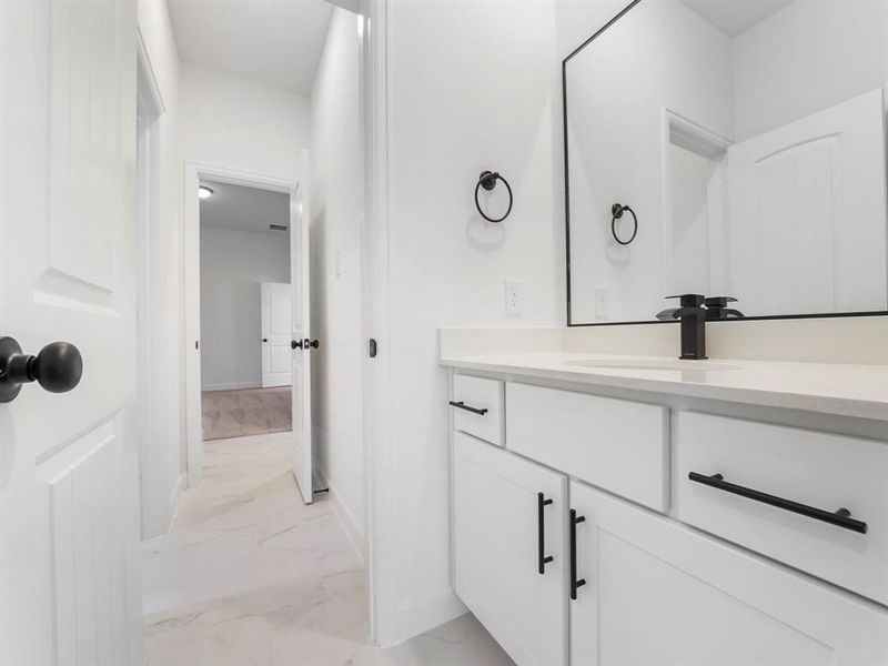 The Jack-and-Jill style bathroom is equipped with two vanities, providing each adjoining room with its own vanity. (Sample photos of a completed Warwick floor plan. The image may feature alternative selections and/or upgrades.)