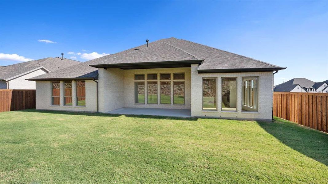 Rear view of property featuring a patio area and a lawn