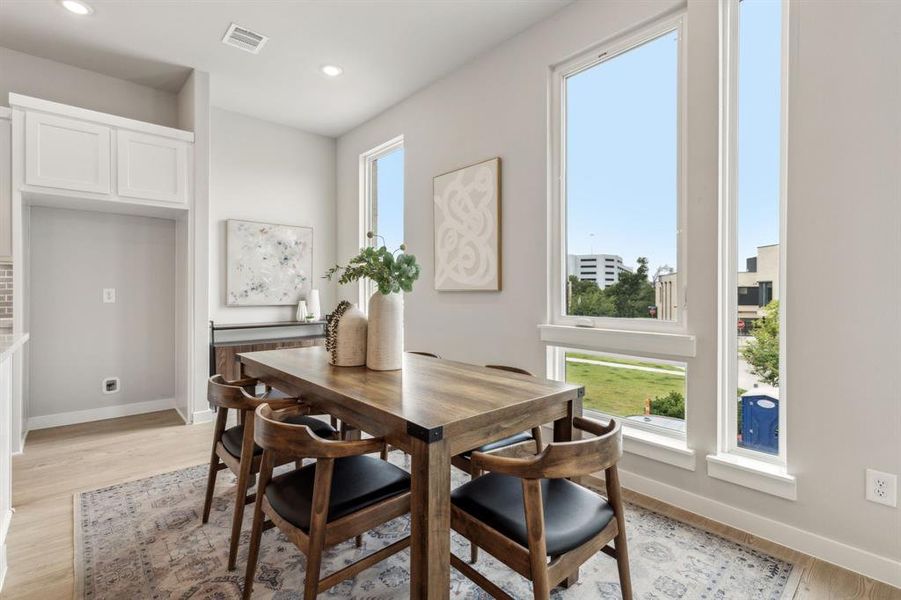 Dining space with a wealth of natural light and light wood-type flooring