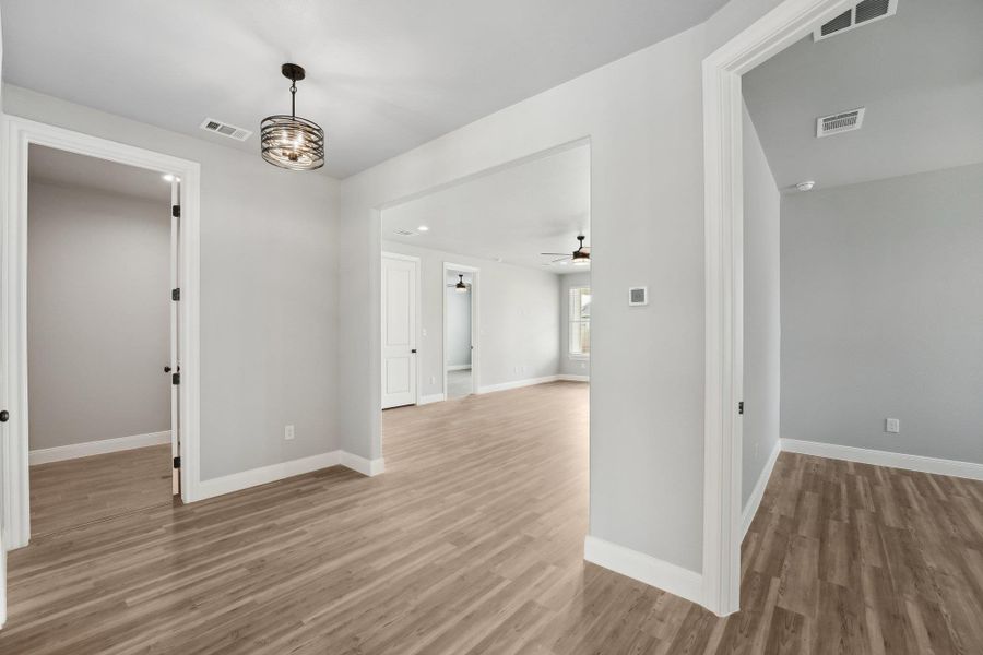 Spare room with visible vents, baseboards, and wood finished floors