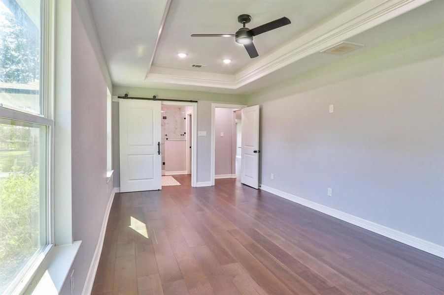 The Size Will Surprise! Spacious primary bedroom with tray ceiling, recessed canned lights and "Bruce Dogwood" engineered wood floors.