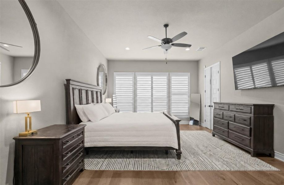 Hardwood floors and bright windows create a naturally illuminated bedroom retreat. Hardwood floors and bright windows create a naturally illuminated bedroom retreat.