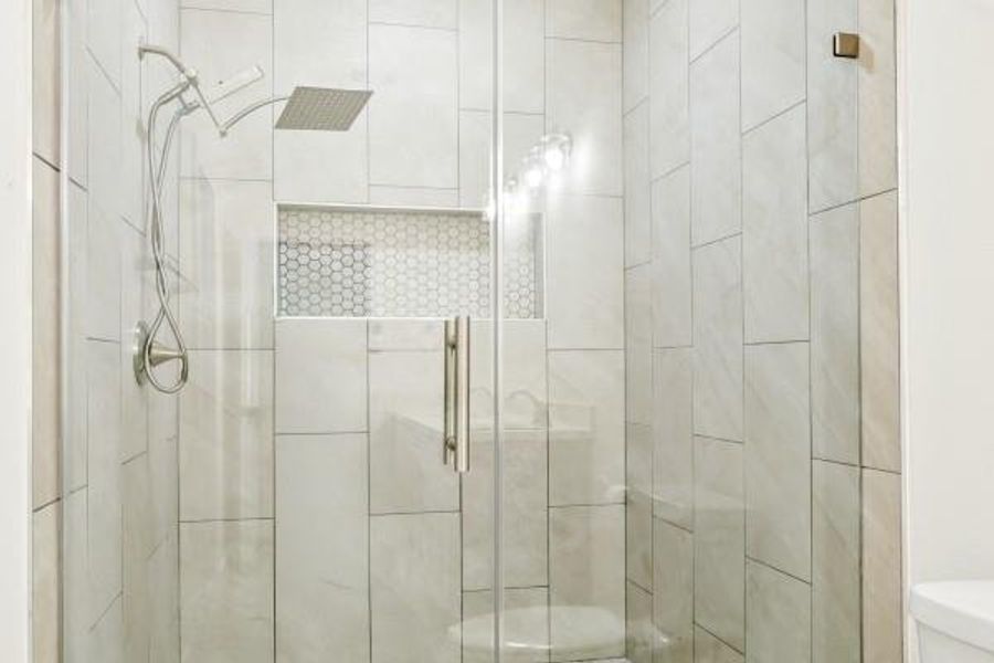 Luxurious standalone shower with sleek glass doors and modern tile design. Luxurious standalone shower with sleek glass doors and modern tile design.