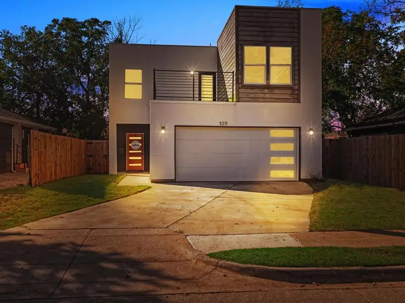 Contemporary house featuring a garage and a lawn