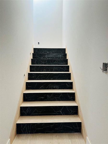 Stairway with wood finished floors and a textured wall Stairway with wood finished floors and a textured wall