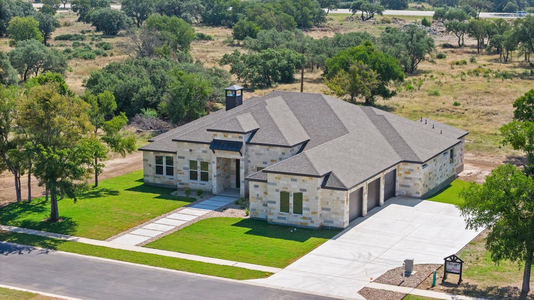 A newly constructed residence showcasing a sophisticated stone facade and an expansive multi-car garage. A newly constructed residence showcasing a sophisticated stone facade and an expansive multi-car garage.