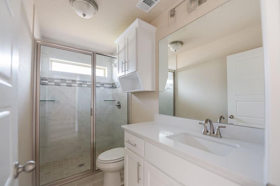 Bathroom with vanity and a marble finish shower Bathroom with vanity and a marble finish shower