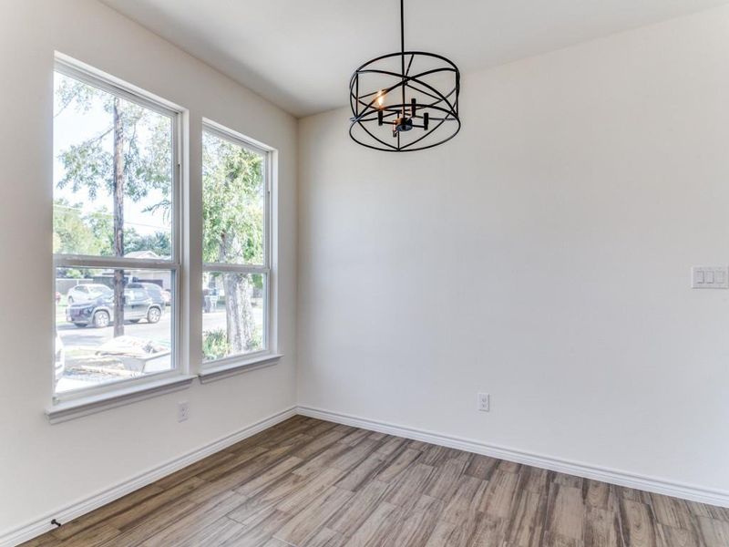 Empty room with an inviting chandelier and light wood-type flooring