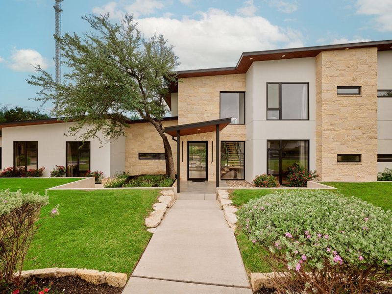 Clean lines and natural stone accents define this inviting contemporary facade with ample lawn space. Clean lines and natural stone accents define this inviting contemporary facade with ample lawn space.