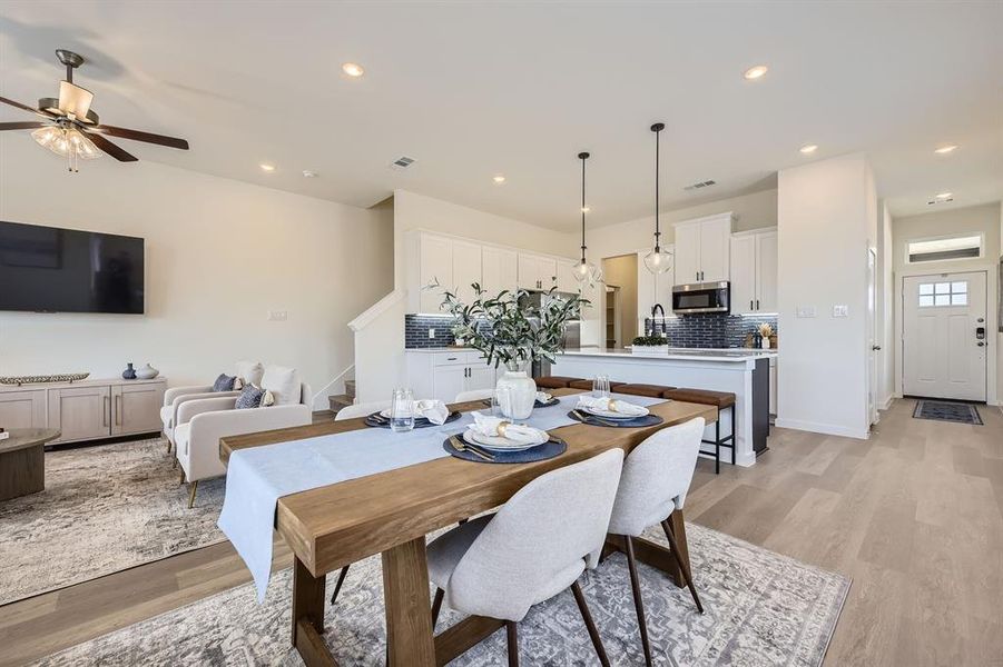 Dining room with light wood finished floors, stairs, recessed lighting, and a ceiling fan