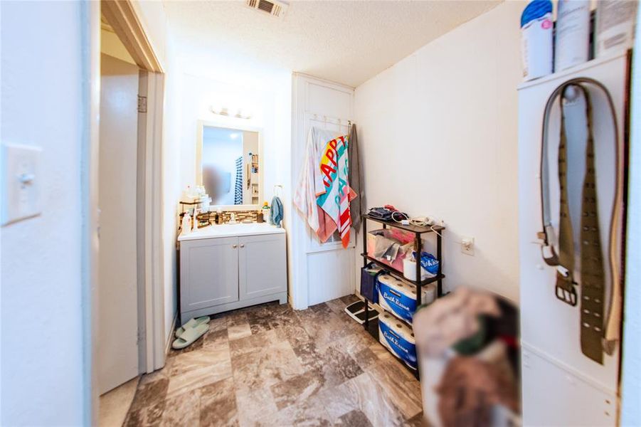 Laundry area with a textured ceiling and a sink