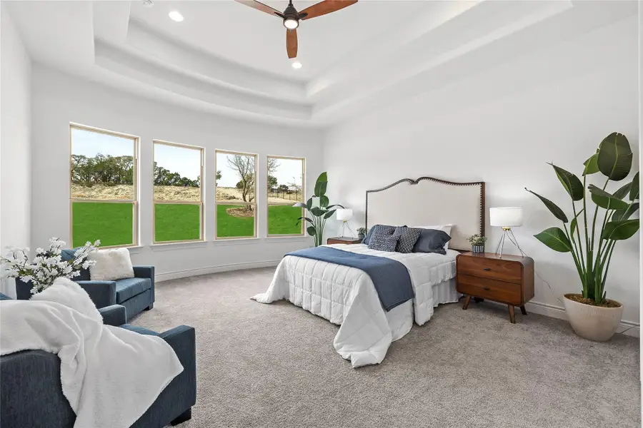 Carpeted bedroom featuring a tray ceiling, recessed lighting, and ceiling fan