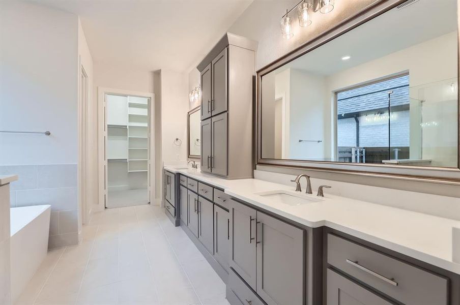 Bathroom with a tub, tile patterned flooring, and vanity