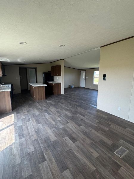 An open floorplan seamlessly connects the kitchen and living areas over low-maintenance wood-look flooring.